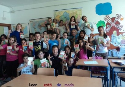 niños con libros y haciendo la L con la mano